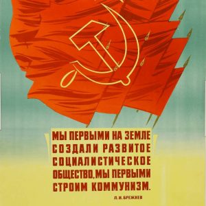 Soviet poster with a red flag, hammer, sickle, and a quote by Brezhnev about building a developed socialist society.